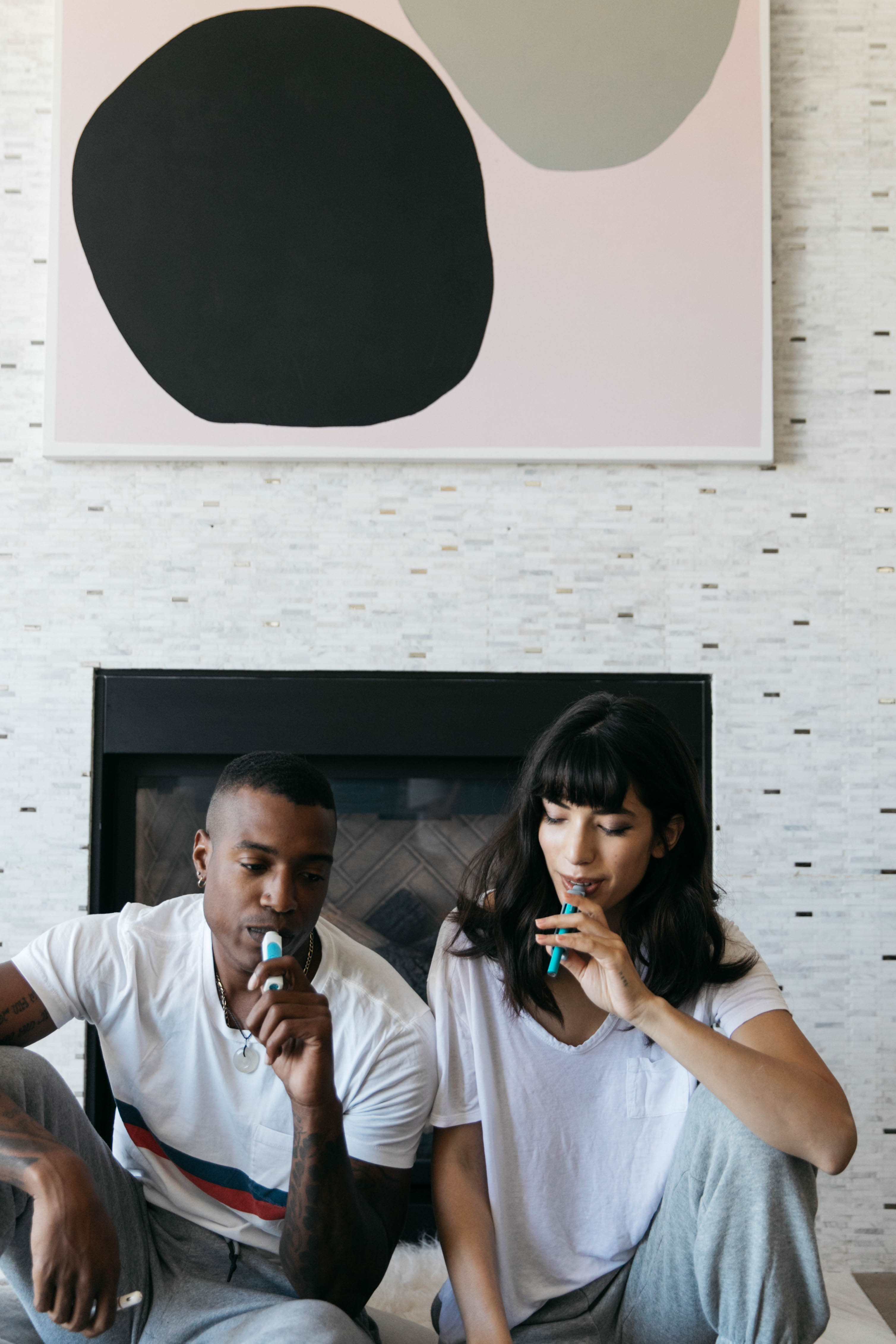Couple relaxing at home by the fireplace, each using a PHILTER POCKET