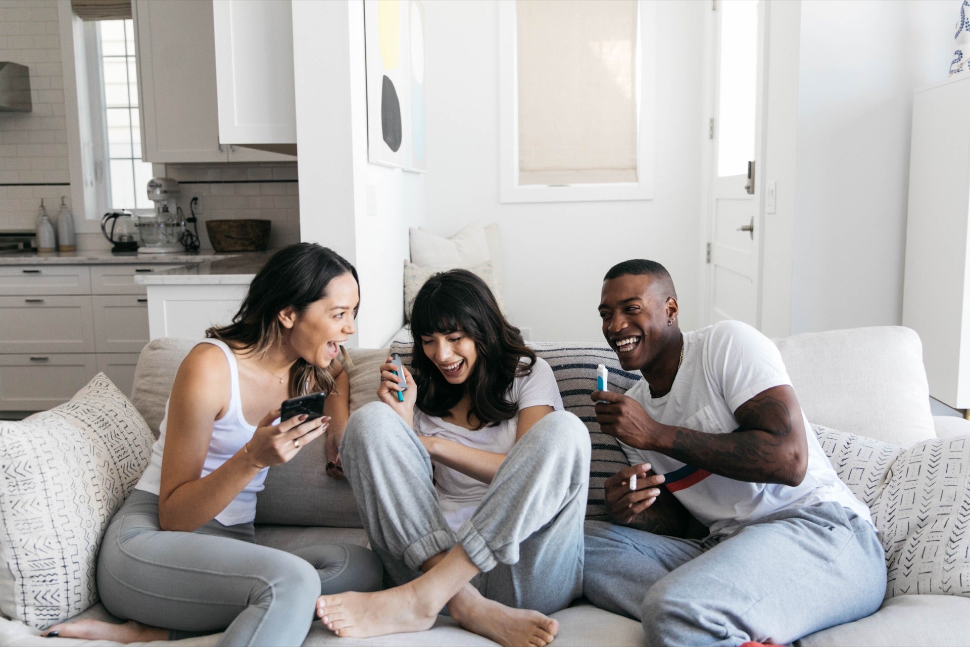 Three friends laughing together on a couch with PHILTER POCKETs