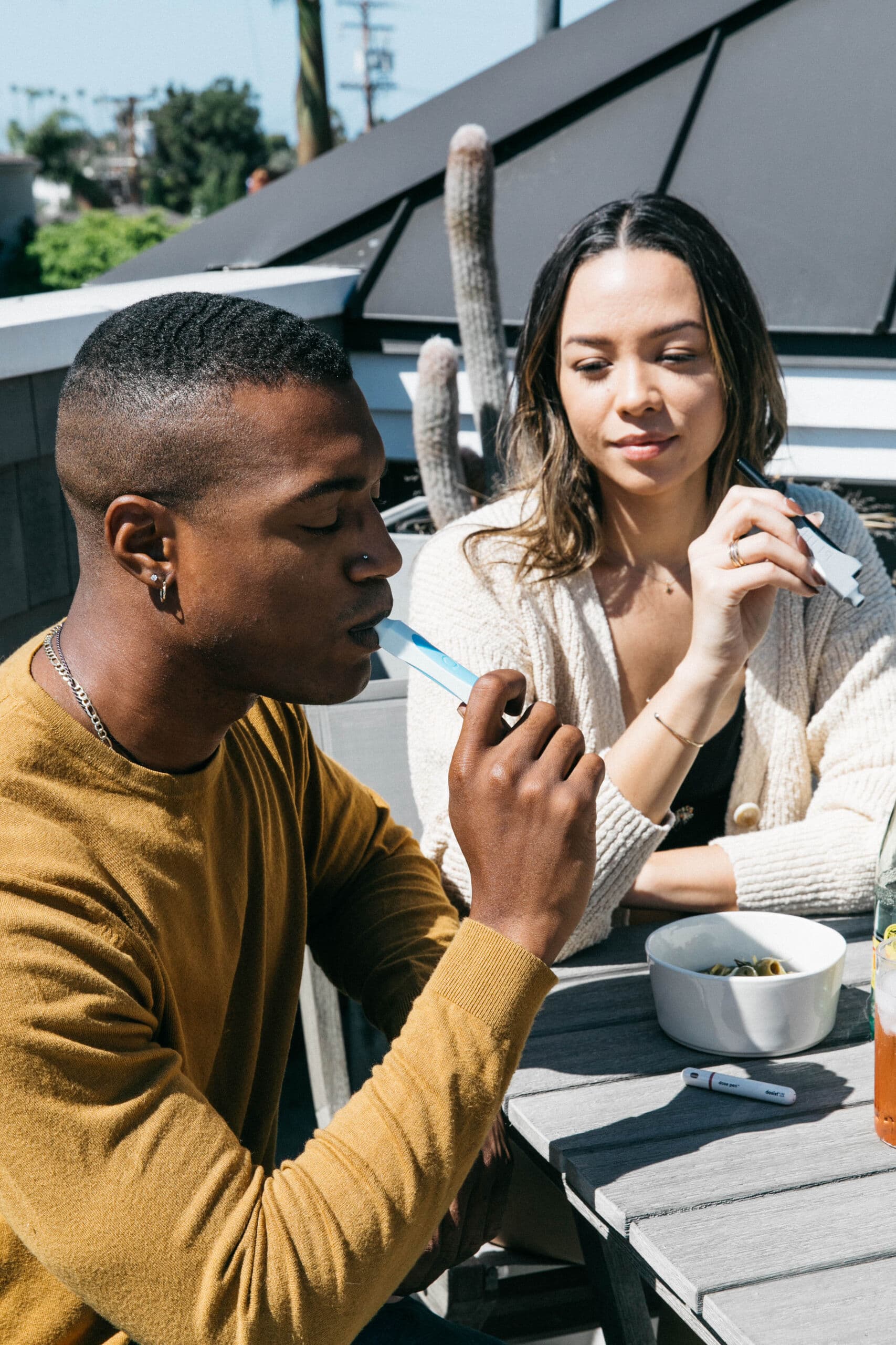 Couple sharing a moment at a rooftop table with PHILTER PHREND device
